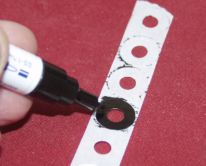 Indelible marker and hole reinforcersused to create centre spot